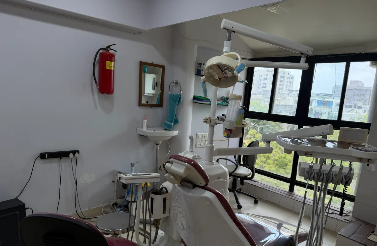 A treatment room at Karnavati Dental Care in Vastrapur, with the dental chair, operating light and instrument delivery unit ready for a procedure