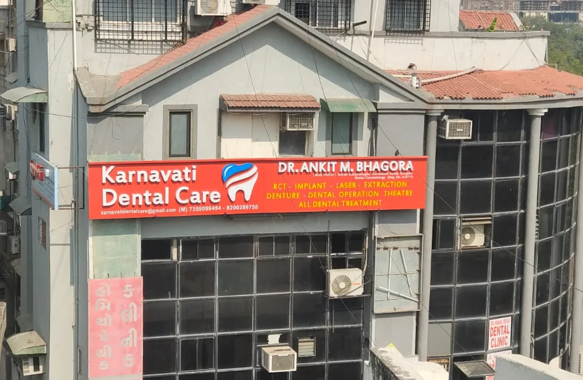 The Karnavati Dental Care building in Vastrapur, Ahmedabad, its red signboard facing the main road